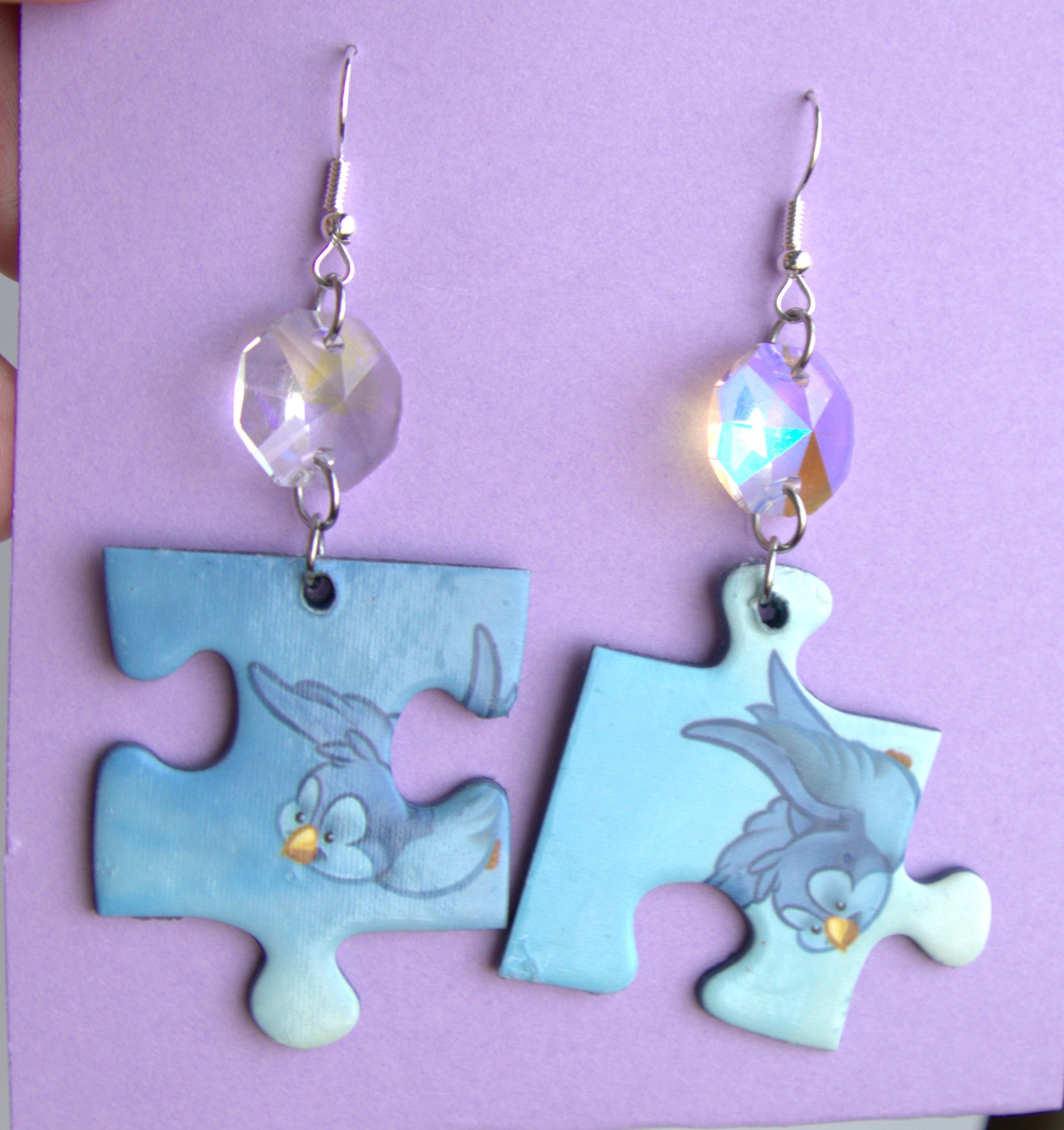 Isot palapelikorvakorut lasiprismalla